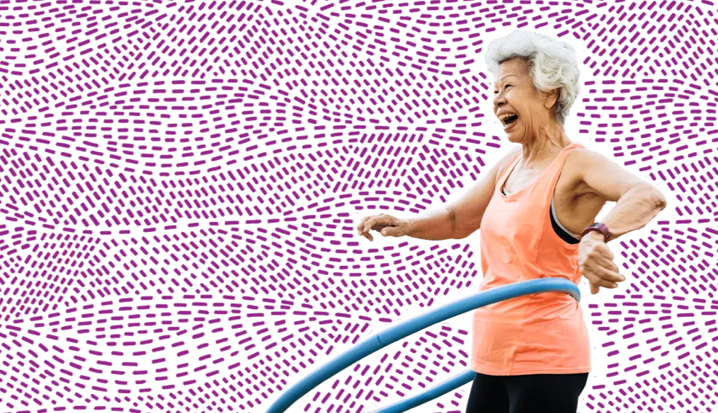 older woman happily exercising with a hoola hoop