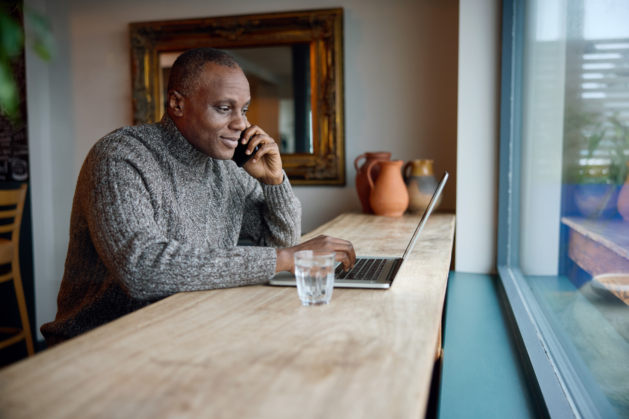 mature man working on laptop at a cafe