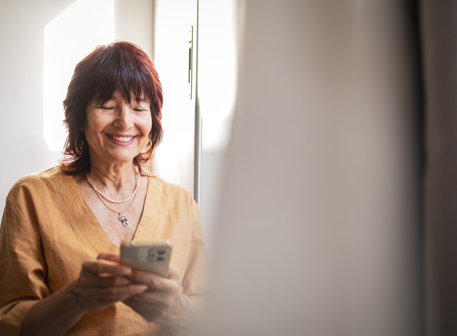 cheerful senior woman looking at her phone