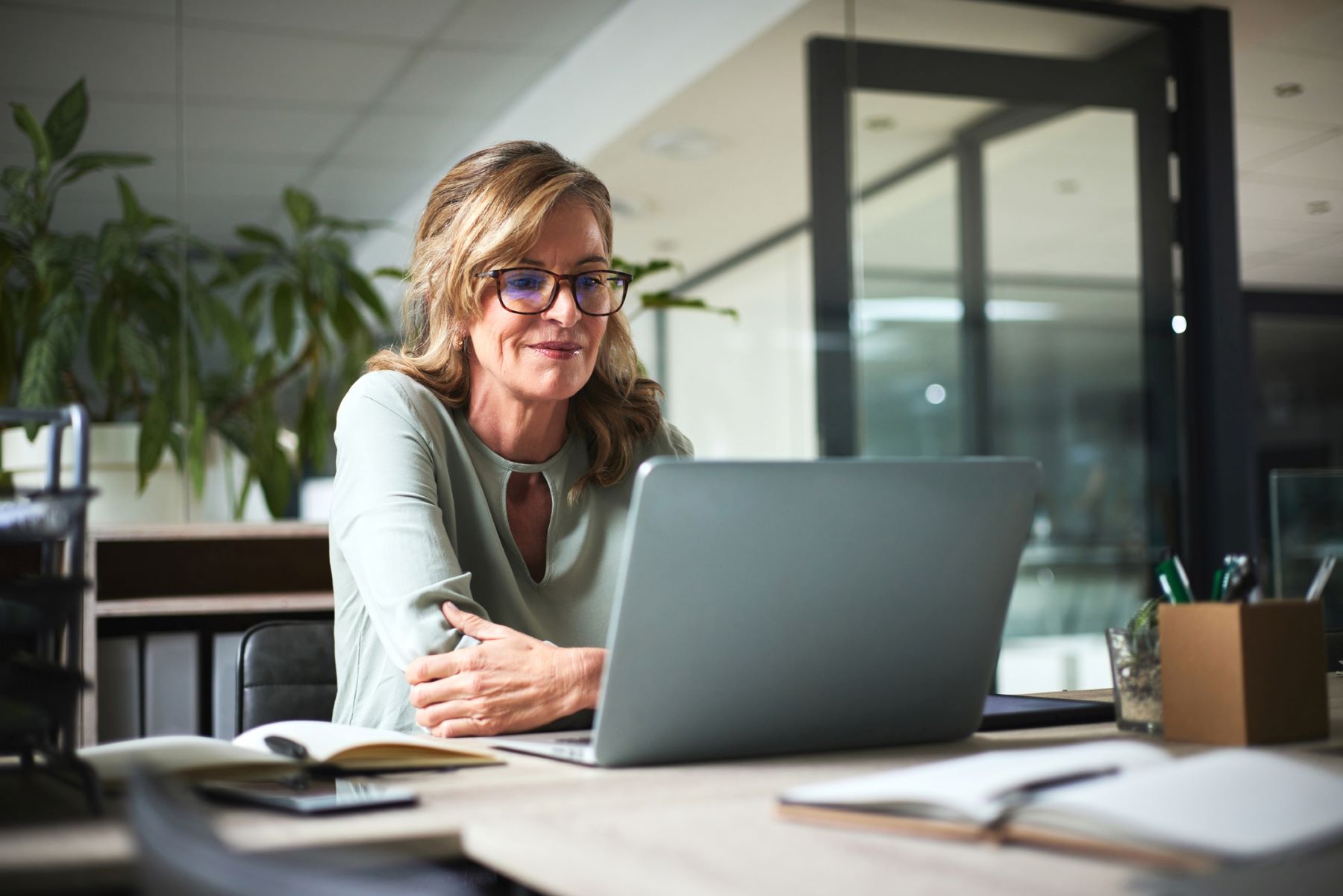 smiling older woman reads on her computer